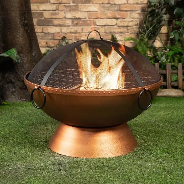 Deko Living COB10512 round wood-burning fire pit shown outdoors with a fire and spark screen
