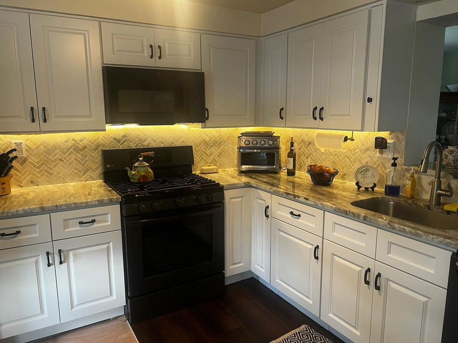 White raised-panel kitchen with under-cabinet lighting