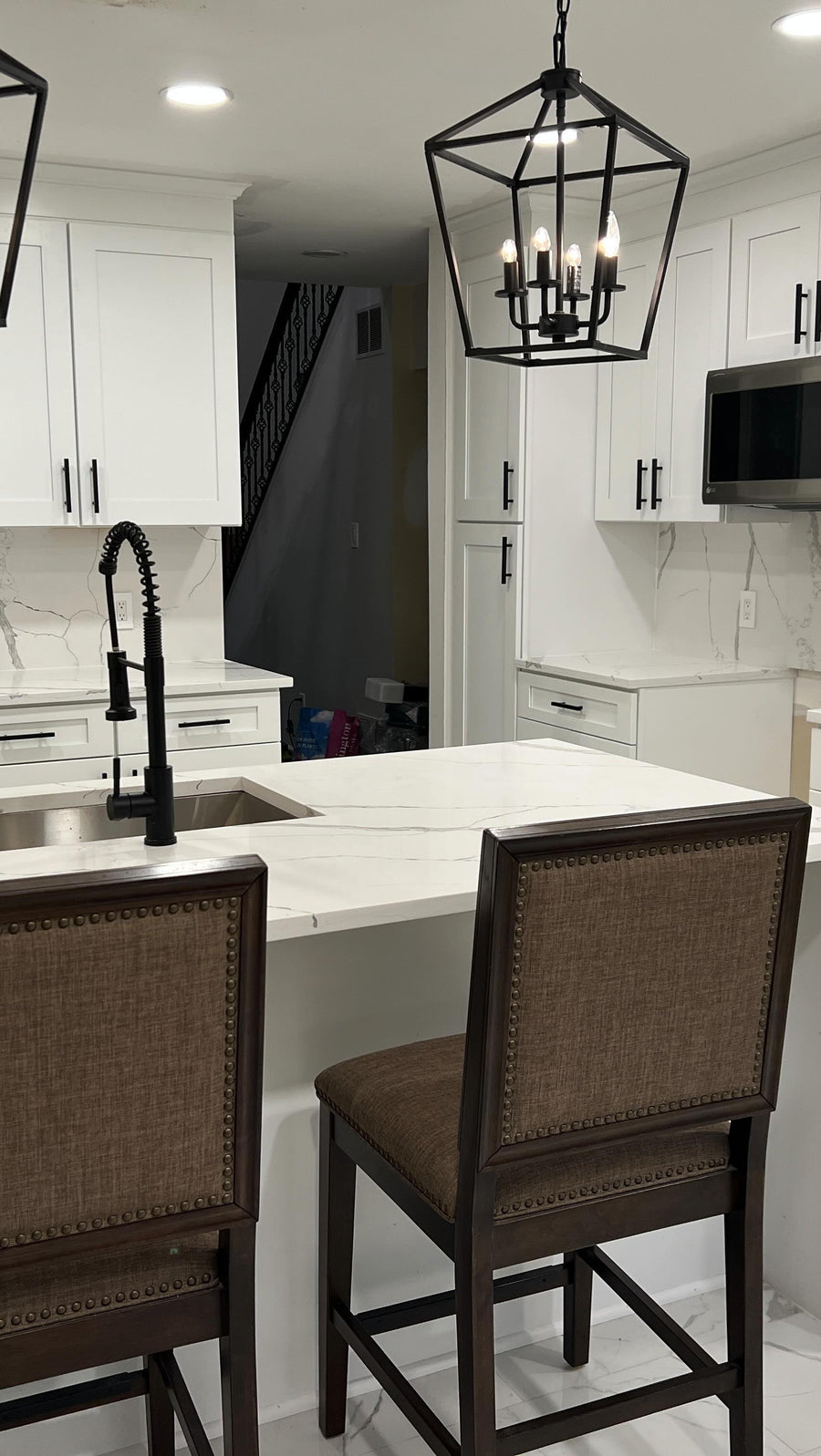 White Shaker kitchen with island and upholstered stools